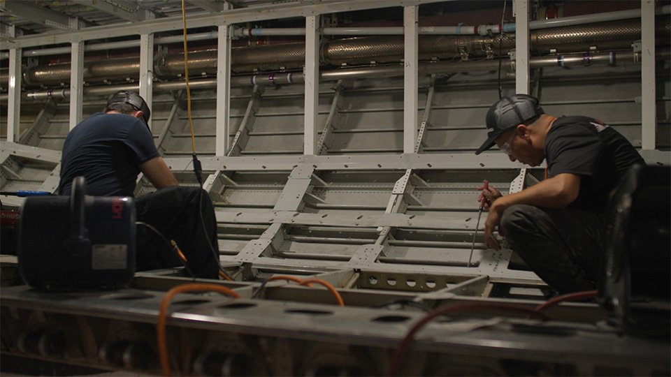 Two employees of Haeco working on a plane